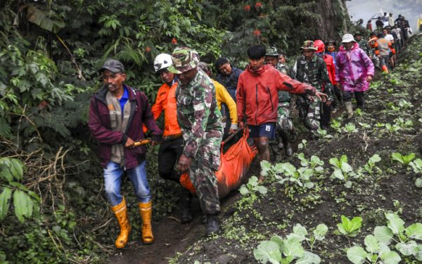 Image: Rescuers carry the body of a victim of the eruption of Mount Marapi